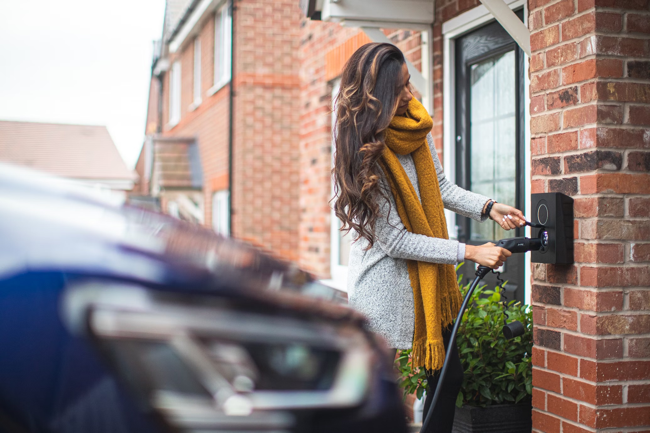 Woman charging car at home